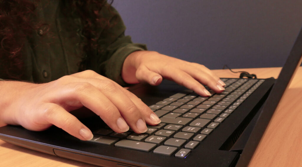 Frau mit Laptop auf Schreibtisch