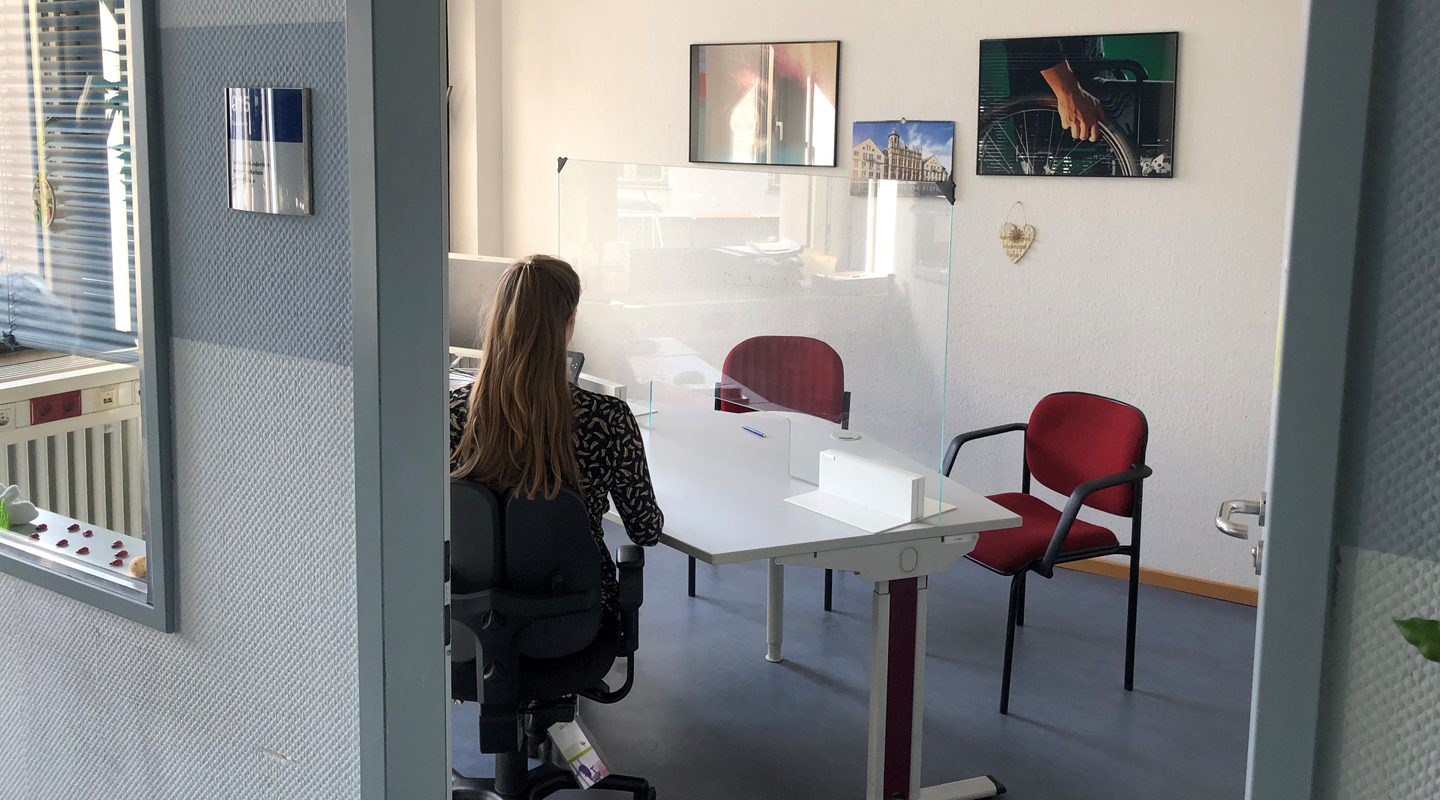 Frau sitzt am Beratungstisch im Servicebüro