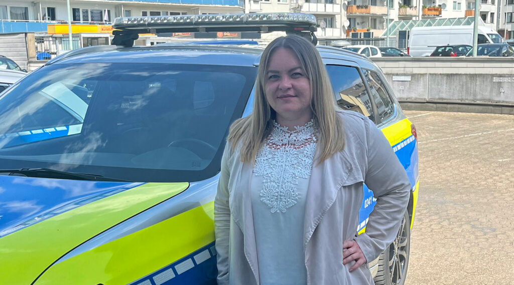 Susanne Aumann steht vor Polizeitauto