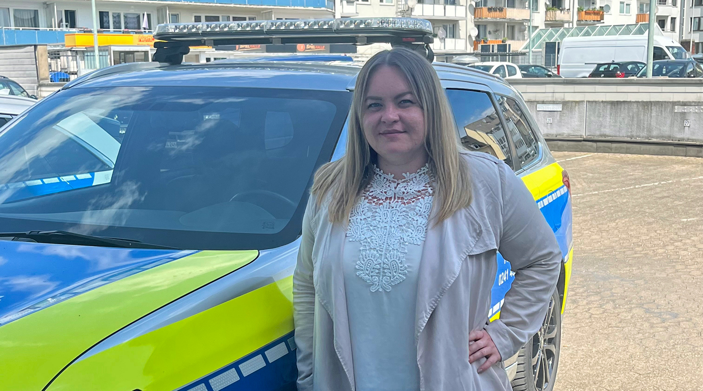 Susanne Aumann steht vor Polizeitauto